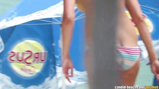 Милфа в голубых стрингах загорает топлес на общественном пляже