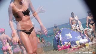 Скрытно снимает крупным планом туристок в бикини на общественном пляже