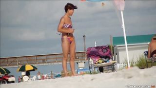 Красивые девушки в бикини развлекаются на пляже перед вуайеристом
