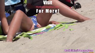 Блондинка в фиолетовом купальнике в рубчик лежит на пляже