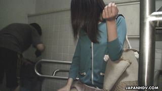 Одетая японка делает минет, сидя на унитазе в общественном туалете