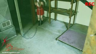 Связанная порно модель с цепью на шее сосёт хуй похитителя в подвале